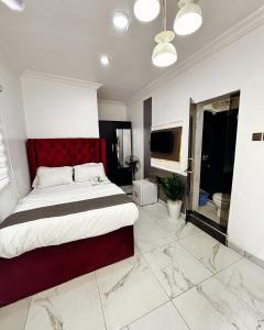 a bedroom with a large bed with a red headboard at Ilewalekki in Lagos