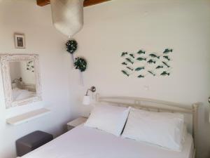 a bedroom with a bed and a mirror and a tub at Maroussa's Apartments in Rámos