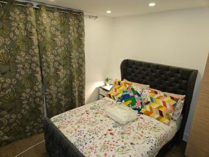 a bedroom with a bed with a flowered blanket at London Glamour Apartments in London