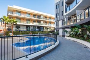 an apartment complex with a swimming pool in front of a building at Casa Nimasa! Penthouse with big rooftop & jacuzzi in Javea in Jávea