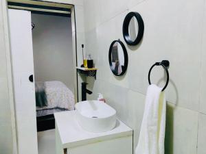 a white bathroom with a sink and a mirror at Tranquil Escapes Bramley in Johannesburg
