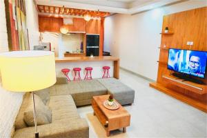 a living room with a couch and a tv and a kitchen at Private 3- bedroom Villa with pool. in Kuta