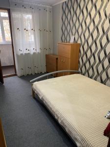 - une chambre avec un lit, une commode et une fenêtre dans l'établissement One Room Apartment, à Chişinău