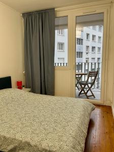 - une chambre avec un lit et une vue sur un balcon dans l'établissement Appartement calme et bien décoré, cours Fauriel, à Saint-Étienne