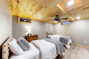 2 bedden in een slaapkamer met een houten plafond bij Upper Gresham Lakehouse in Manitowish Waters