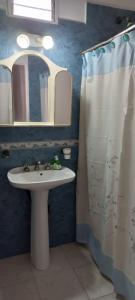 ein Bad mit einem Waschbecken und einem Spiegel in der Unterkunft Departamento zona terminal/parque in Dolores