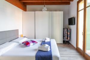 a bedroom with a large white bed and a tv at Lugana Resort & Sporting Club - Sermana Village in Peschiera del Garda