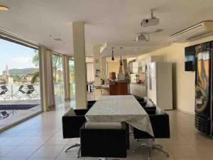 a living room with a table and a kitchen at Mansão Casa Blanca em São Roque c/ 5 vagas garagem in São Roque