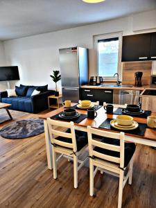 cocina y sala de estar con mesa y sillas en Lions Place Premium Apartments COMFORT optionaler Zugang zum SPA- Bereich, en Heidenheim an der Brenz