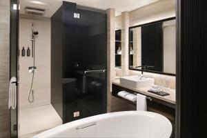 a bathroom with a tub and a sink and a shower at Sheraton Grand Hotel, Dubai in Dubai