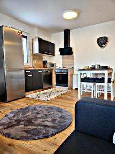 a kitchen with a stainless steel refrigerator and a table at Lions Place Premium Apartments COMFORT optionaler Zugang zum SPA- Bereich in Heidenheim an der Brenz