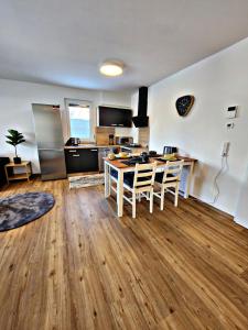 a kitchen and living room with a table and chairs at Lions Place Premium Apartments COMFORT optionaler Zugang zum SPA- Bereich in Heidenheim +36 photos
