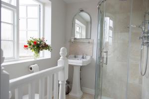 a bathroom with a sink and a shower with a mirror at Watership Down Inn in Whitchurch