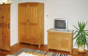 Zimmer mit einem TV auf einer Kommode mit einem Holzschrank in der Unterkunft 4 Bedroom Pet Friendly Home In Neukirchen Am Grossven, in Neukirchen am Großvenediger