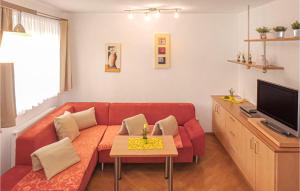 a living room with a red couch and a tv at Beautiful Apartment In Rauris With 4 Bedrooms And Internet in Rauris