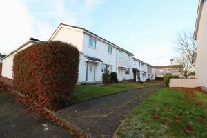 una casa con un arbusto al lado de una calle en Signature - Glen Garry House, en East Kilbride