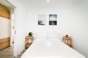 um quarto branco com uma cama e duas mesas de cabeceira em Costa de la creu 10, Piso 4 personas 1 min playa em Lloret de Mar