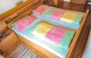 una cama de madera con sábanas de colores encima. en 2 Bedroom Cozy Home In Radstadt en Radstadt