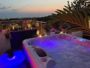 een jacuzzi op een balkon 's nachts bij Spa de la Lune - Private love room suite with terrace and view - Air Conditioned- Double jacuzzi - Sauna - King size bed - Free WIFI - Free parking - Free breakfast - Close to CDG airport and to the North of Paris in Clichy-sous-Bois