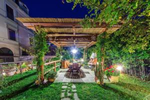 a garden with a pergola and a table and chairs at B&B La Casa Nel Giardino in Piano di Sorrento