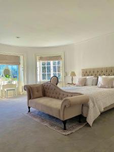 a large bedroom with a bed and a couch at Denham Mount in Buckinghamshire