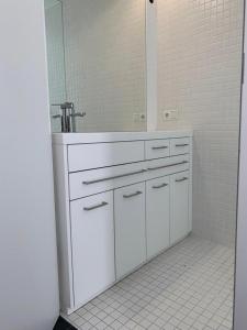 La salle de bains blanche est pourvue d'un lavabo et d'un miroir. dans l'établissement Motel by Maier Feldkirch - kontaktloser Check-in, à Feldkirch