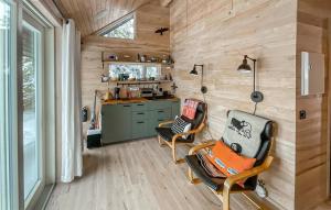 a tiny house with two chairs and a kitchen at Sjusjen Pihl 4020 in Sjusjøen