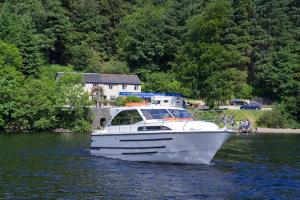 a white boat on the water in a lake at Caley Cruisers in Inverness