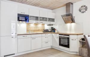 a white kitchen with white cabinets and a sink at Ferienhaus 34 Altefähr in Altefähr