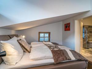 Un dormitorio con una cama grande y una ventana en Penthouse Julia nähe Badesee mit Überwassermassage und Infrarotsauna, en Niedernsill