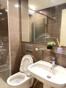 a bathroom with a white toilet and a sink at The Serene Escape Rockwell Makati City View 1BR in Manila