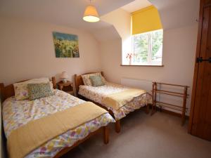 um quarto com 2 camas e uma janela em 3 Bed in Askerswell DC067 
