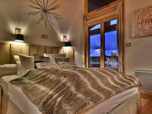 a bedroom with a large bed with a large window at Superbe T6 au centre des Gets - 10 pers, 5 ch, parking, wifi, linge inclus - FR-1-685-7 in Les Gets