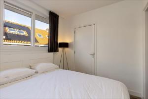 a bedroom with a bed with a trainseen through a window at Nice apartment in the city center Kerkakker 1 in Eindhoven