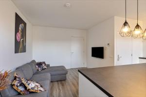 uma sala de estar com um sofá e uma mesa em Nice apartment in the city center Kerkakker 1 em Eindhoven