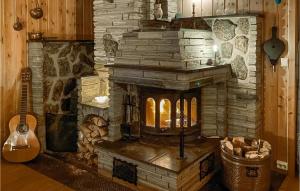 a stone fireplace in a room with a guitar at Stunning Home In Aurdal With House A Mountain View in Aurdal