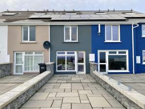 una casa azul con un patio frente a ella en Cottage 437 - Ballyconneely, en Ballyconneely