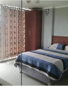 a bedroom with a bed and a glass wall at HOTEL TERRA in Ayacucho