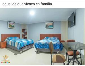una camera con due letti e un tavolo in vetro di HOTEL TERRA ad Ayacucho