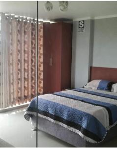 a bedroom with a bed and a glass wall at HOTEL TERRA in Ayacucho
