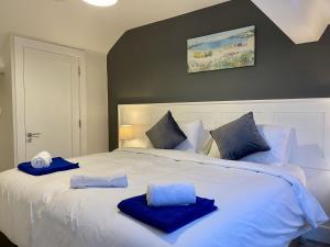 Una gran cama blanca con toallas azules. en Cottage 437 - Ballyconneely, en Ballyconneely