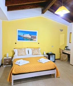 シラクーサにあるTre Archi B&Bのベッドルーム1室(黄色い壁の大型ベッド1台付)