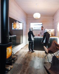 a couple of children standing in a room with a man at Nova Galaxy Village in Rovaniemi