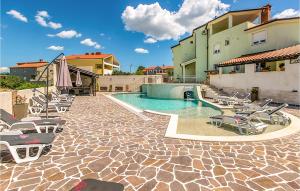 uma piscina com espreguiçadeiras e um edifício em Amazing Apartment In Pula With Outdoor Swimming Pool em Pula