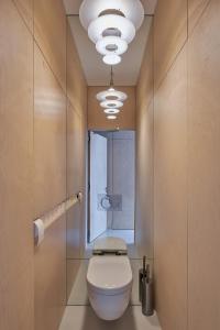 een badkamer met een wit toilet en een raam bij LE GARAGE Downtown serviced apartment in Den Haag +45 foto's