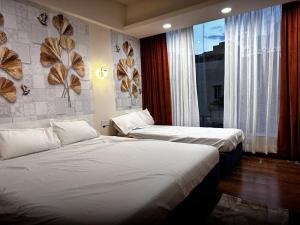 two beds in a hotel room with a window at Hotel shree mahakal krapa in Ujjain