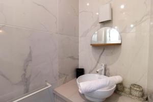 een witte badkamer met een toilet en een spiegel bij Apartment Center of Paris by Studio prestige in Parijs