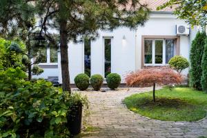 una casa bianca con un passaggio in mattoni di Green and Blue Garden Apartments a Belgrado