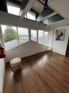 an empty room with two chairs and windows at Hostal Sur Y Magia in Coihaique