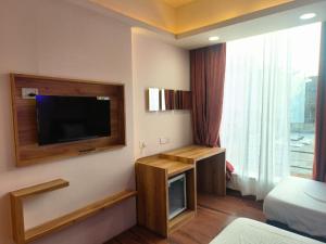 a room with a flat screen tv on a wall at Hotel shree mahakal krapa in Ujjain